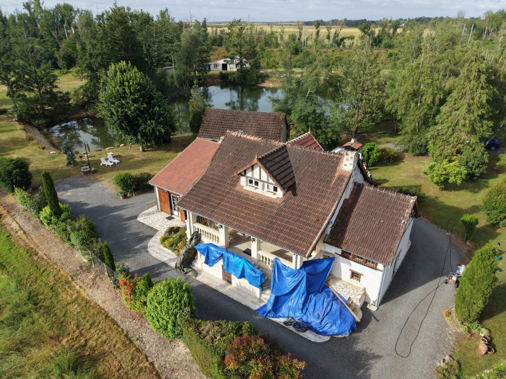 Vue drone avant démoussage : toiture brun sombre et bâches de protection, Gondecourt